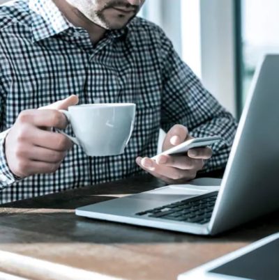 A man sipping coffee and using online banking platform