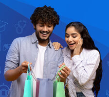 Shopaholics overjoyed indian couple holding shopping bags looking inside excited about their new purchases