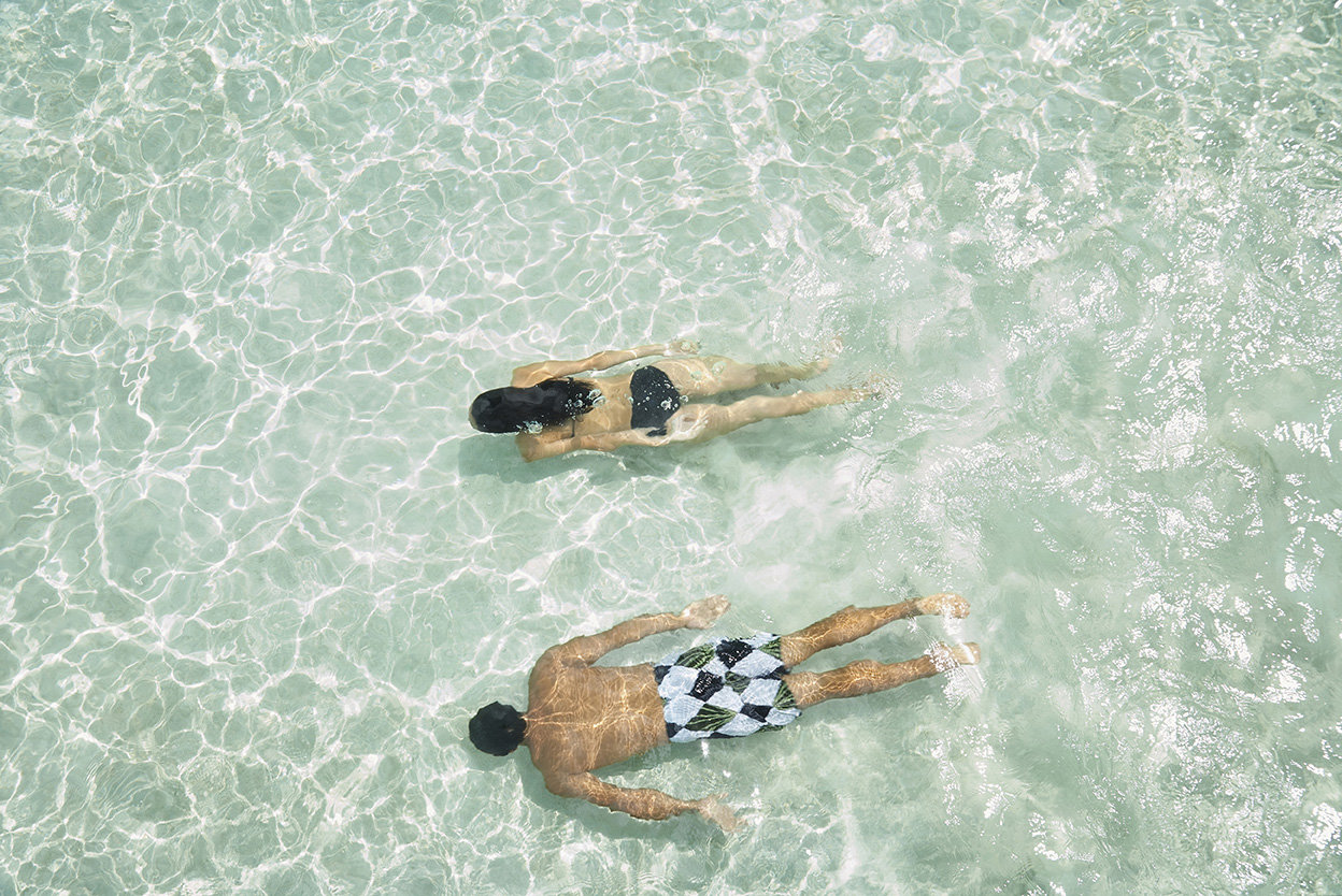 Overhead view of pacific islander couple swimming in tropical oc