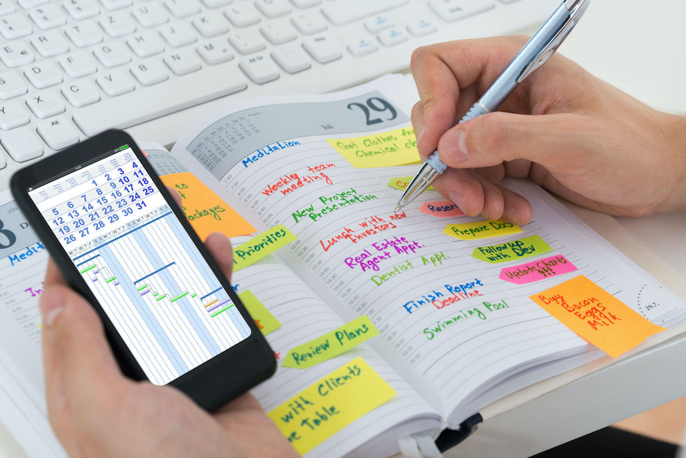 Person hands with mobile phone and diary