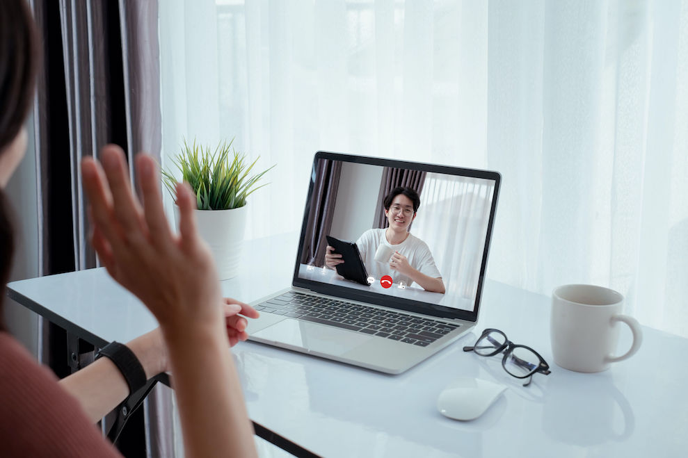 Woman doing yoga while watching instructional videos on laptop