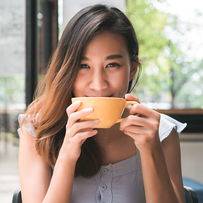 a girl smiling while drinking from a cup