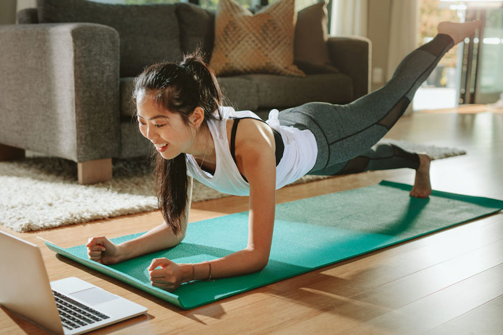 Woman watching sports training online on laptop