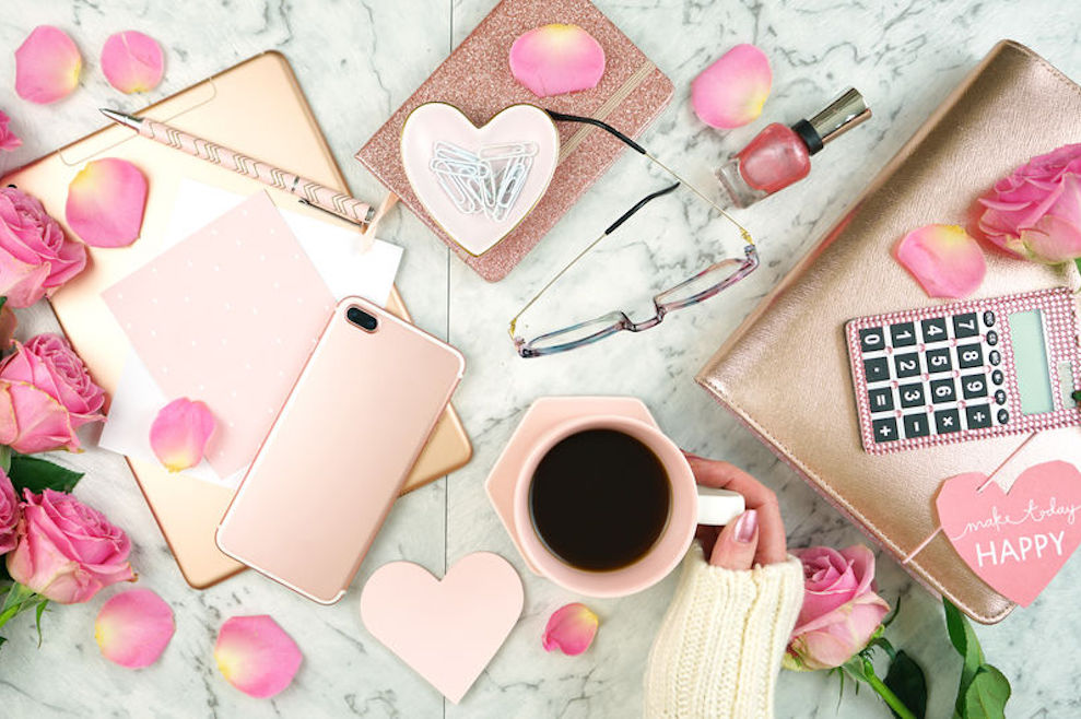 Ultra feminine pink desk workspace with rose gold accessories flatlay
