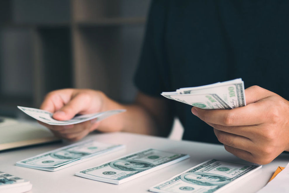 Asian men are holding banknotes in cash and placed on the table with the idea of saving money