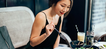 Young woman eating food at the restaurant